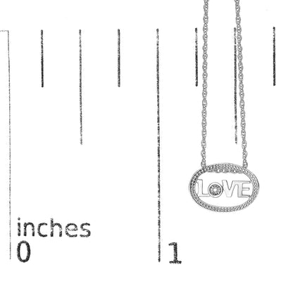 Close-up front view of a white necklace with an oval pendant featuring the word 'LOVE' and a round white gemstone in the center, shown on a ruler for size reference.