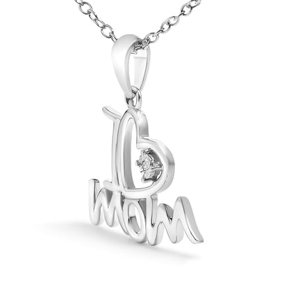 Close-up front angle of a white metal necklace pendant shaped with the word 'mom' and an attached heart outline featuring a single round white gemstone in a prong setting.
