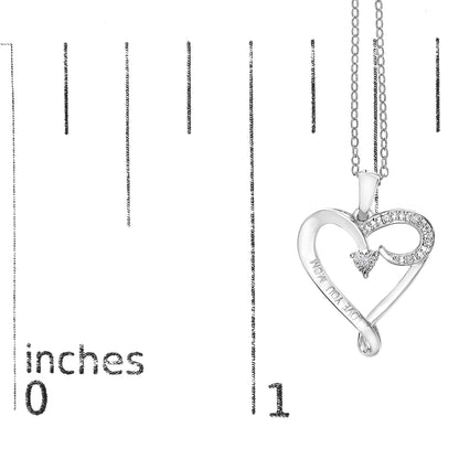 White heart-shaped necklace pendant with five round white gemstones in prong settings, shown on a ruler for size reference, angled slightly to the right.