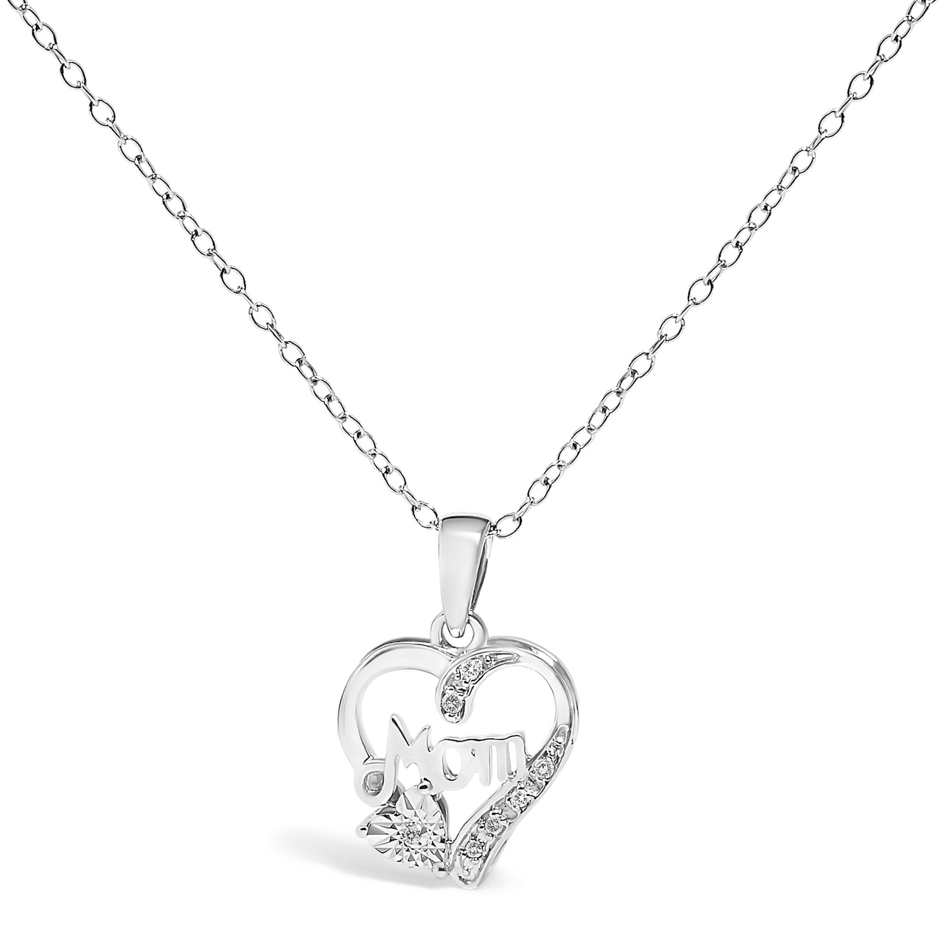 Front angle view of a white metal heart-shaped necklace pendant with the word 'Mom' inside, adorned with round white gemstones in prong settings along one side and on a small heart shape at the bottom left, hanging from a white metal chain.