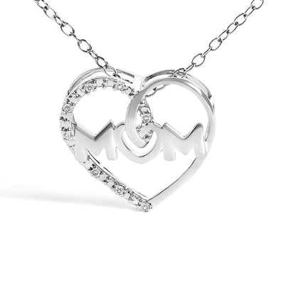 Front angle view of a white metal heart-shaped necklace pendant with the word 'MOM' inside, partially adorned with round white gemstones in prong settings along one side of the heart.