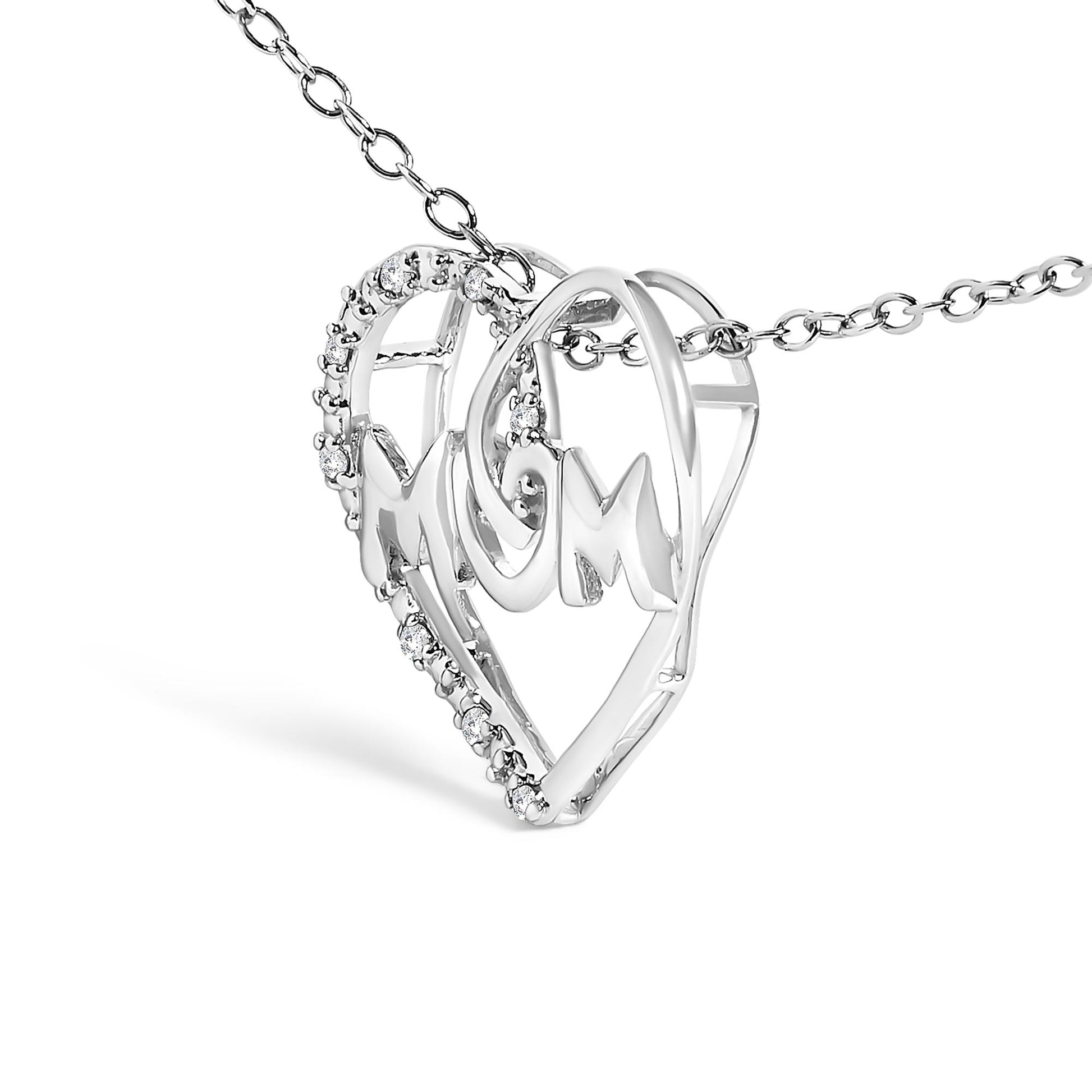Close-up angled view of a white metal heart-shaped necklace pendant with the word 'MOM' in the center, adorned with round white gemstones in prong settings along part of the heart outline.