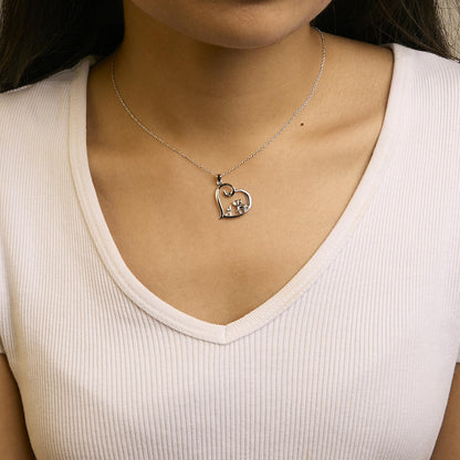 Close-up front view of a model wearing a white metal necklace with an open heart-shaped pendant featuring four round white gemstones in prong settings.