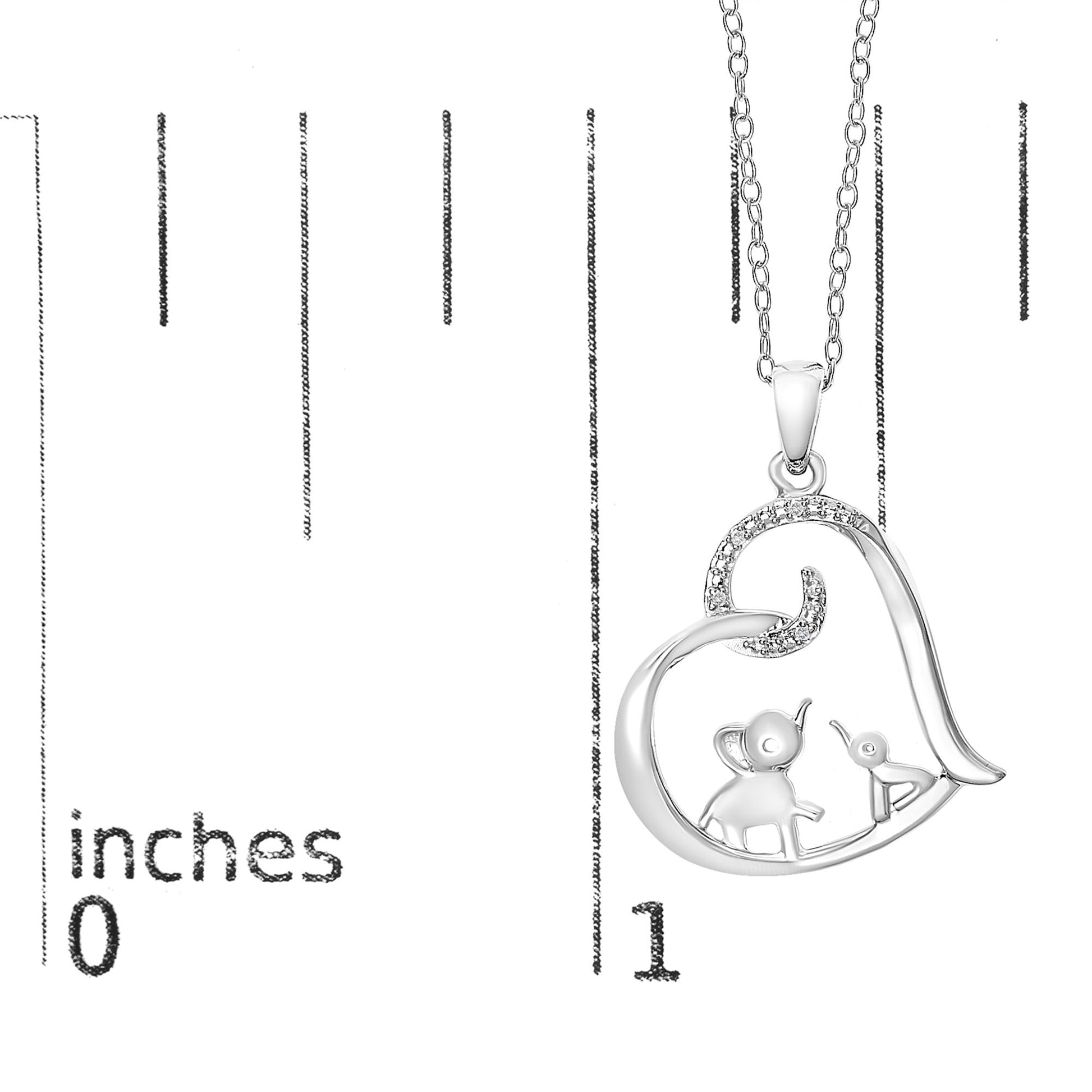 White metal heart-shaped necklace pendant with an elephant and bird inside, accented with round white gemstones, shown on a ruler for size reference, front angle.