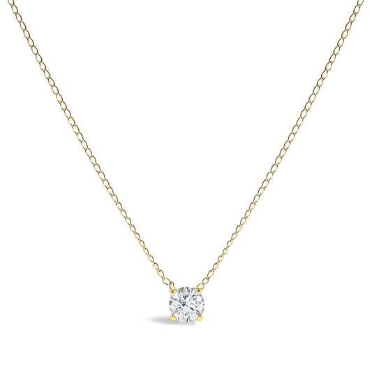 Front-facing shot of a yellow metal necklace with a single round white gemstone in a four-prong setting pendant.