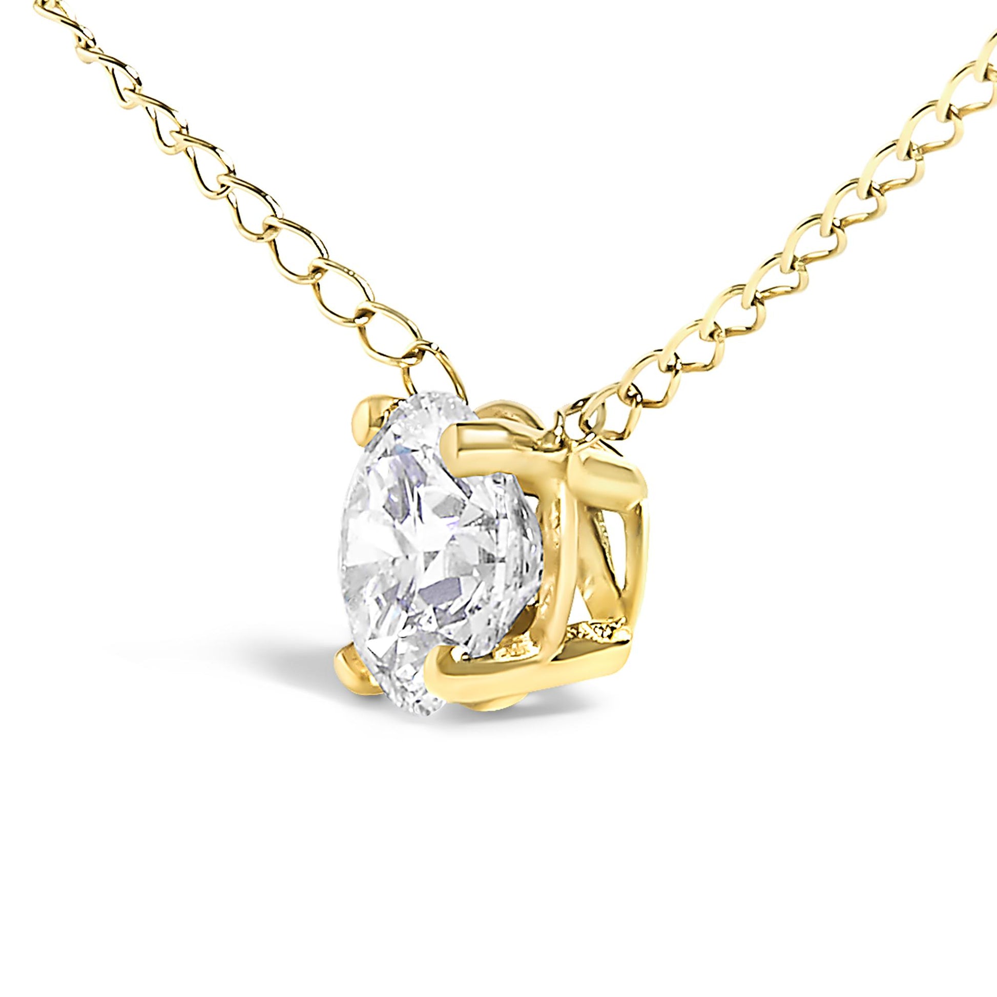 Close-up angled view of a yellow metal necklace with a round white gemstone in a four-prong setting.