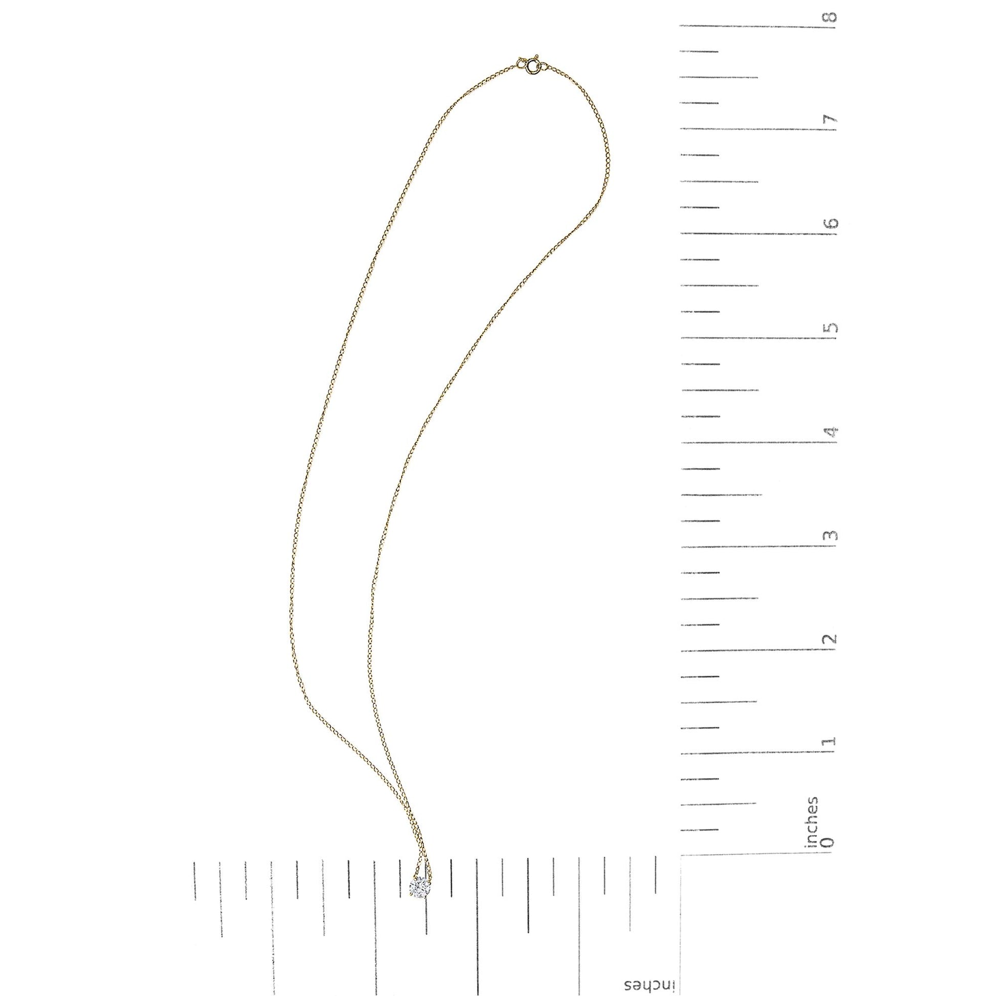 Yellow metal necklace with a single round white gemstone in a 4-prong setting, shown flat on a scale, top view.
