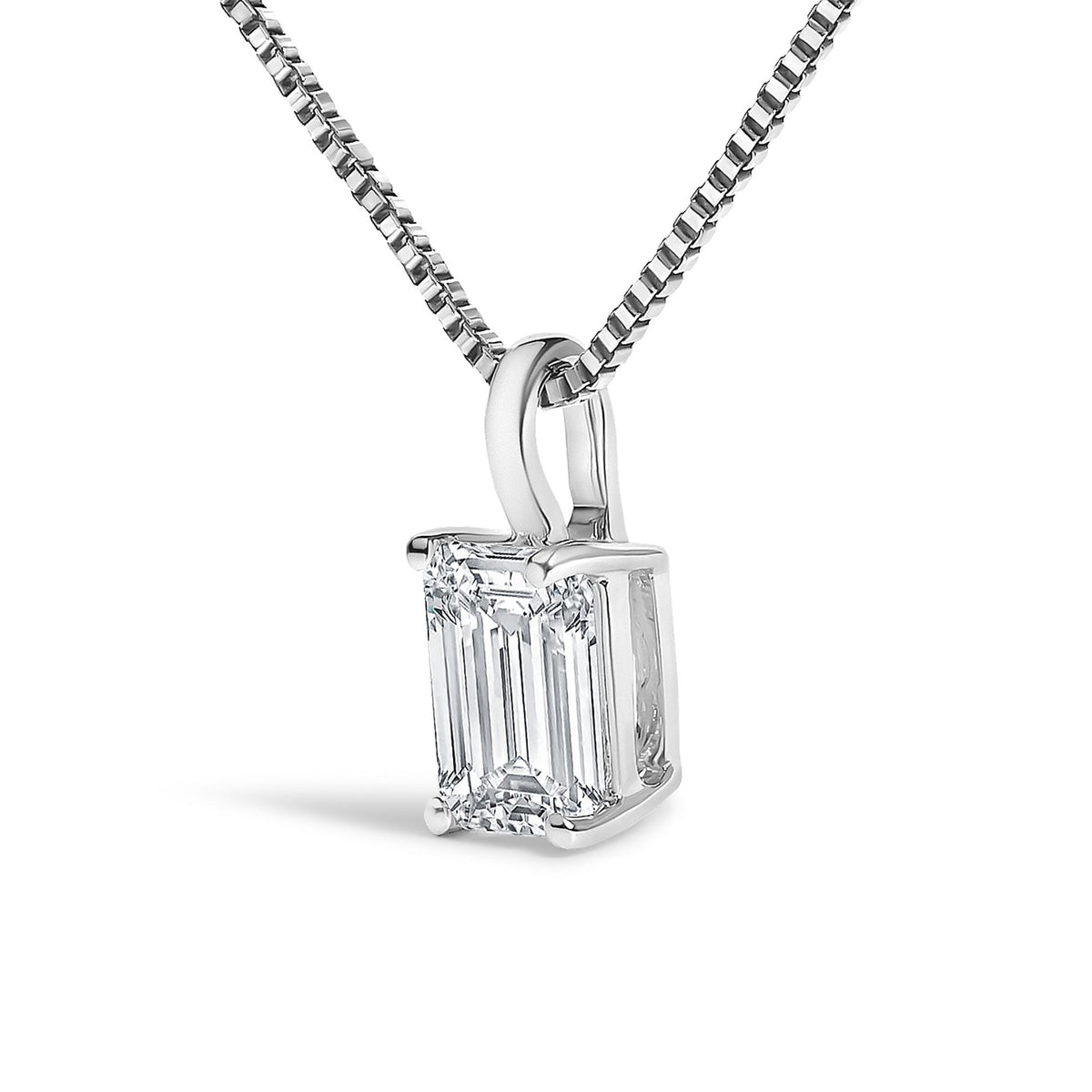 Close-up angled view of a white metal necklace featuring a pendant with a single emerald-shaped white gemstone in a four-prong setting.