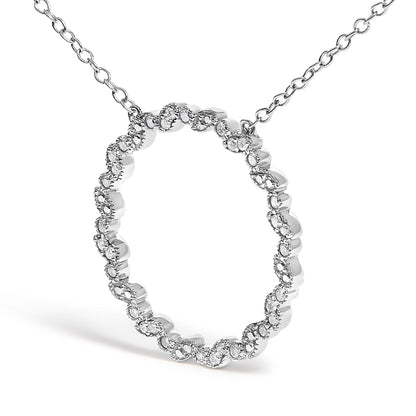 White metal necklace with a circular pendant featuring a wavy pattern set with round white gemstones, shown at a slight front angle.