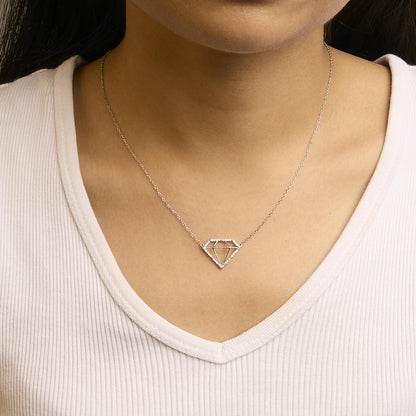 Close-up front view of a white metal necklace with a geometric pendant outlined by round white gemstones, worn on a model.