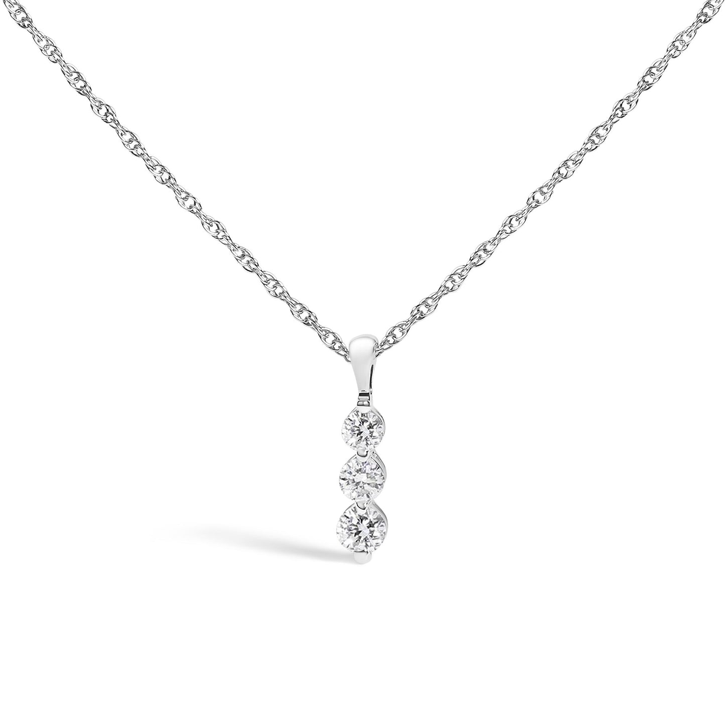 Front-facing shot of a white metal necklace with a pendant featuring three vertically aligned round white gemstones in prong settings.