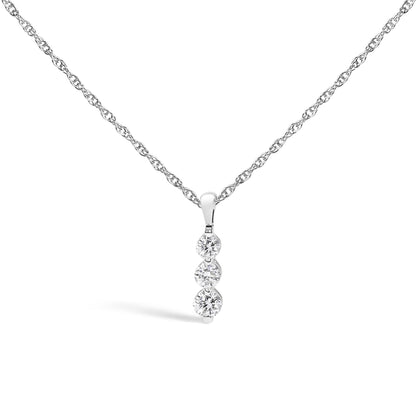 Front-facing shot of a white metal necklace with a pendant featuring three vertically aligned round white gemstones in prong settings.