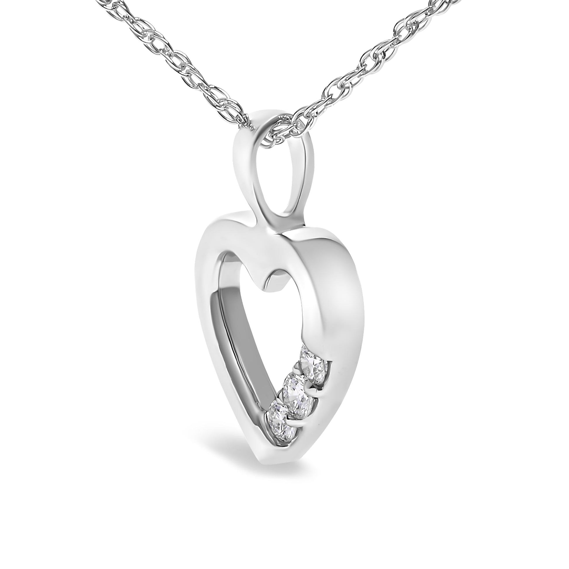 Close-up front angle of a white metal heart-shaped necklace pendant with three round white gemstones in prong settings along one side, hanging from a matching chain.
