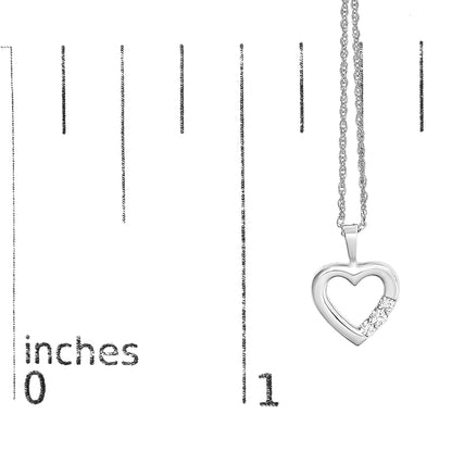 Close-up front view of a white metal heart-shaped necklace pendant with three round white gemstones set in prongs on the lower right side, shown against a ruler for size reference.