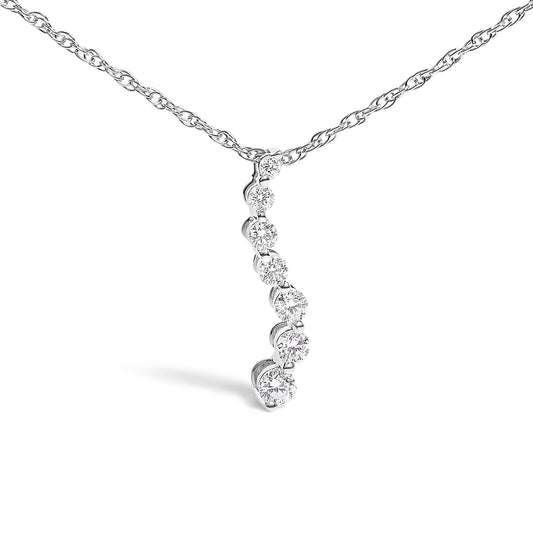 Close-up front angle of a white necklace with a vertical pendant featuring seven round white gemstones in prong settings.