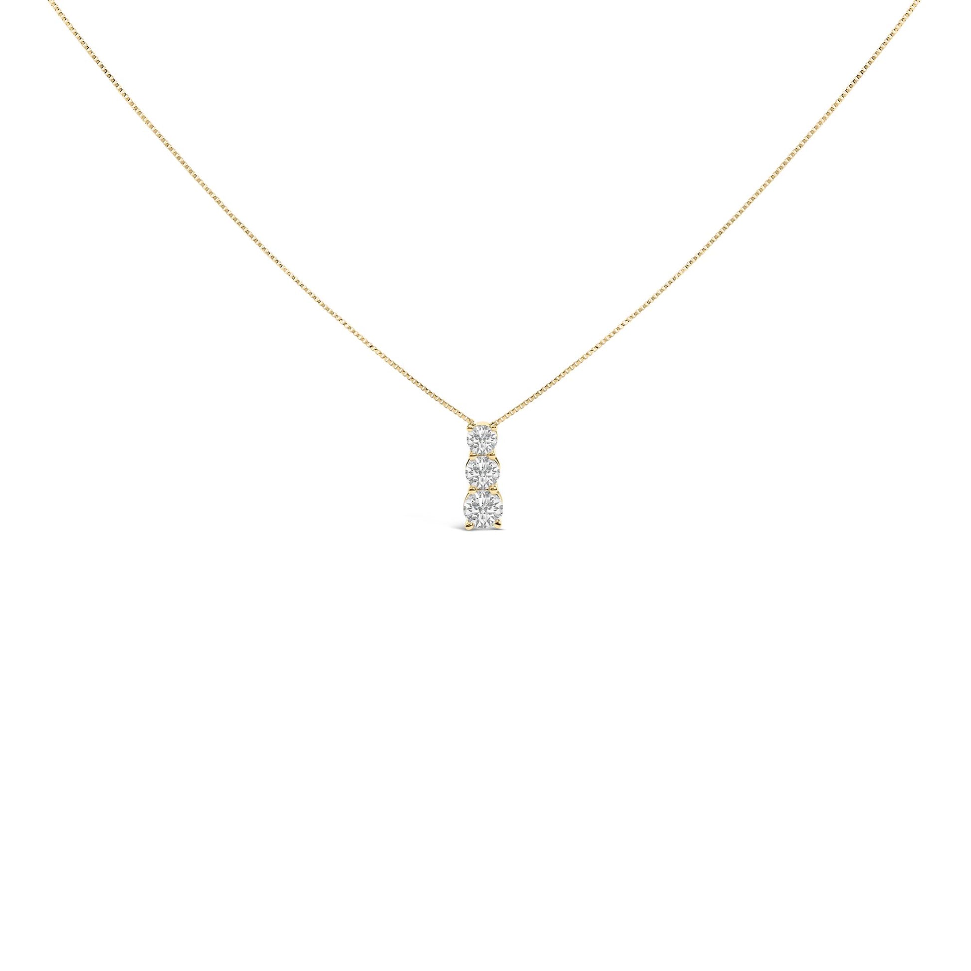 Front angle view of a yellow metal necklace with a vertical pendant featuring three round white gemstones in a shared prong setting.