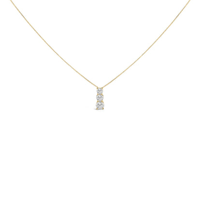 Front angle view of a yellow metal necklace with a vertical pendant featuring three round white gemstones in a shared prong setting.