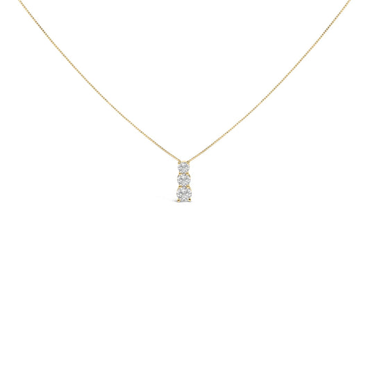 Front angle view of a yellow metal necklace with a vertical pendant featuring three round white gemstones in a shared prong setting.