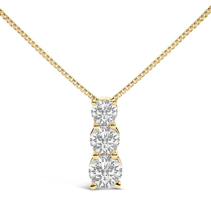 Close-up front view of a yellow metal necklace with a vertical pendant featuring three round white gemstones in a shared prong setting.