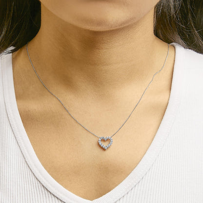 Necklace with white metal chain and heart-shaped pendant adorned with round white gemstones, shown worn on a model, front close-up angle.