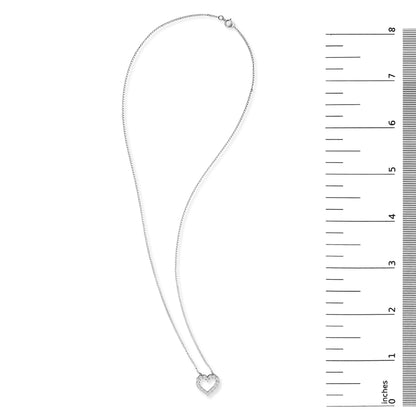 White metal necklace with a heart-shaped pendant adorned with round white gemstones in shared prong settings, shown flat on a white background next to a ruler scale.