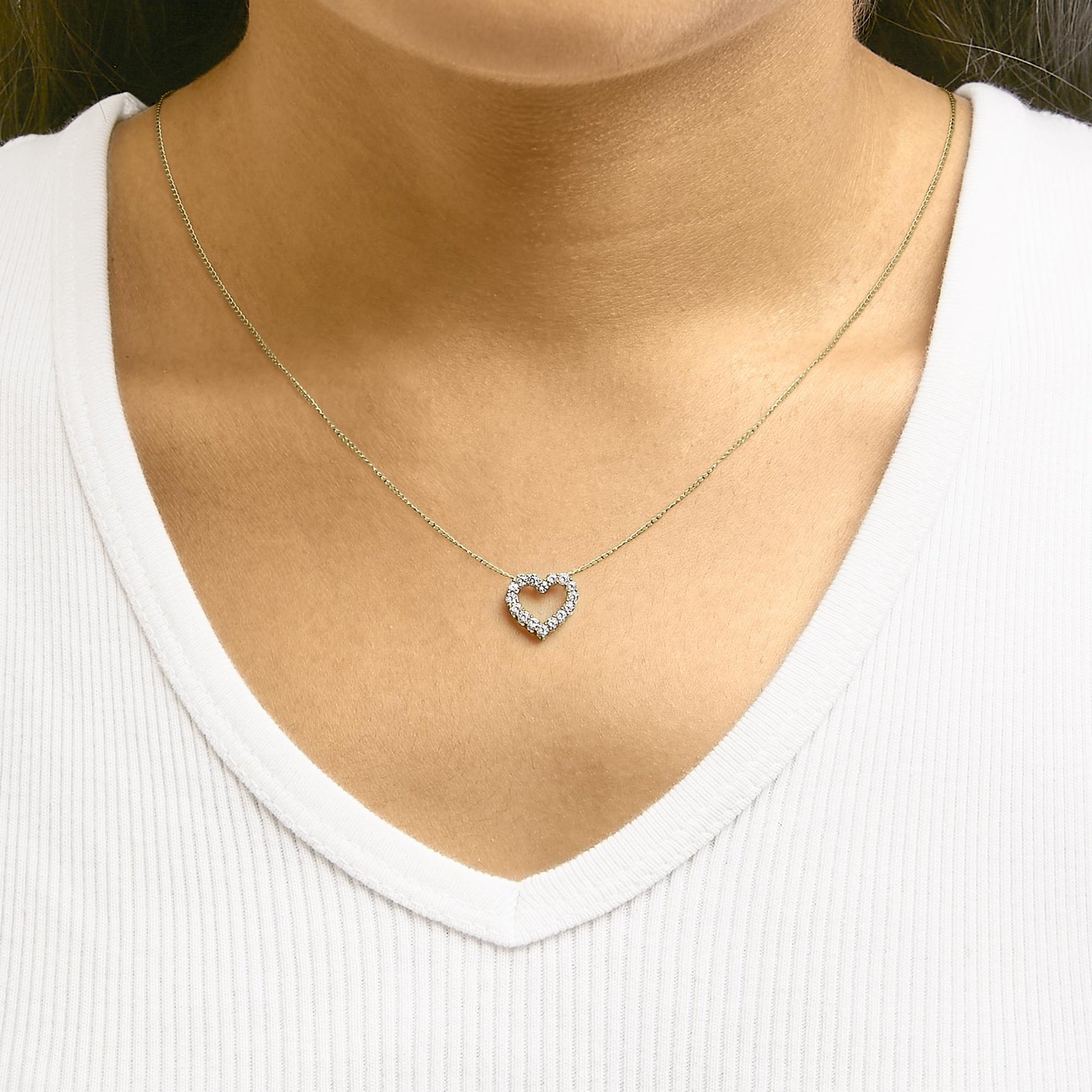 Yellow necklace with a heart-shaped pendant featuring white round gemstones in a shared prong setting, shown worn on a model from the front angle.