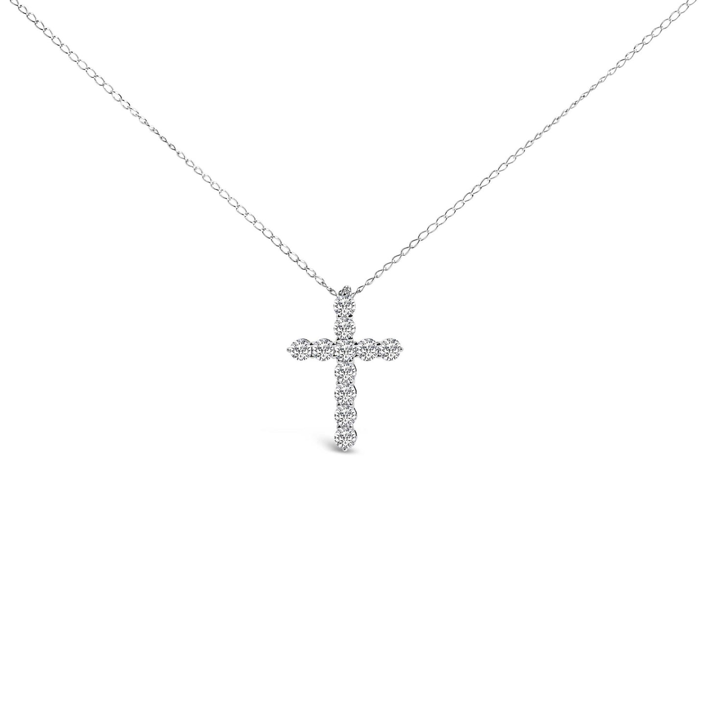 Front-facing shot of a white necklace with a cross-shaped pendant composed of round white gemstones in a shared prong setting.