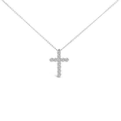 Front-facing shot of a white necklace with a cross-shaped pendant composed of round white gemstones in a shared prong setting.