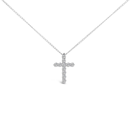 Front-facing shot of a white necklace with a cross-shaped pendant composed of round white gemstones in a shared prong setting.