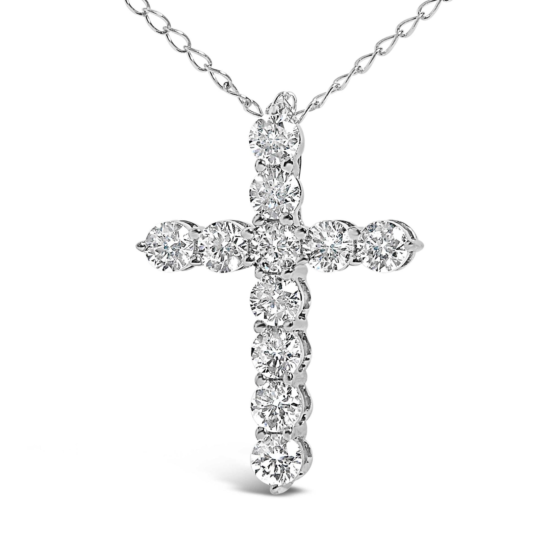 Close-up front view of a white metal necklace featuring a cross-shaped pendant with round white gemstones in shared prong settings.