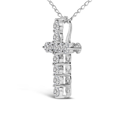 Close-up front angle of a white metal cross necklace pendant featuring round white gemstones in a shared prong setting, suspended on a linked chain.