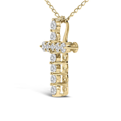 Close-up front angle of a yellow metal cross-shaped necklace pendant with round white gemstones set in shared prong settings, shown on a chain against a white background.