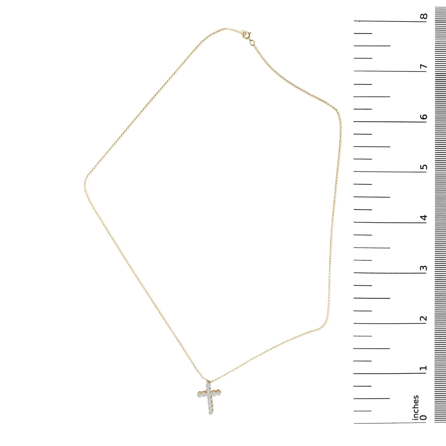 Yellow necklace with a small cross pendant set with round white gemstones in shared prong settings, shown laying flat next to a ruler for scale, image taken from above.