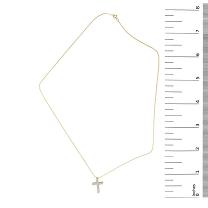 Yellow necklace with a small cross pendant set with round white gemstones in shared prong settings, shown laying flat next to a ruler for scale, image taken from above.