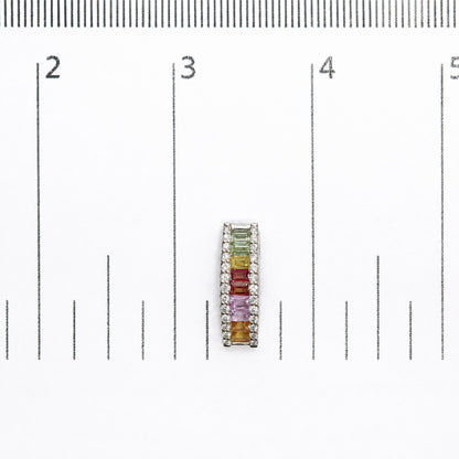 Single white metal earring shown on a measurement scale, viewed from above, featuring a vertical row of multicolored baguette-shaped gemstones with round white gemstones bordering both sides.