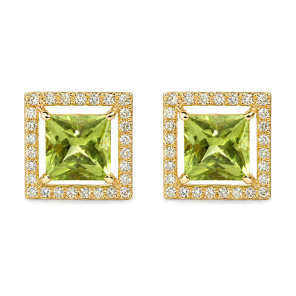 Close-up front angle of a pair of yellow metal square-shaped earrings featuring a large green princess-cut gemstone in the center, surrounded by small round white gemstones in prong settings.