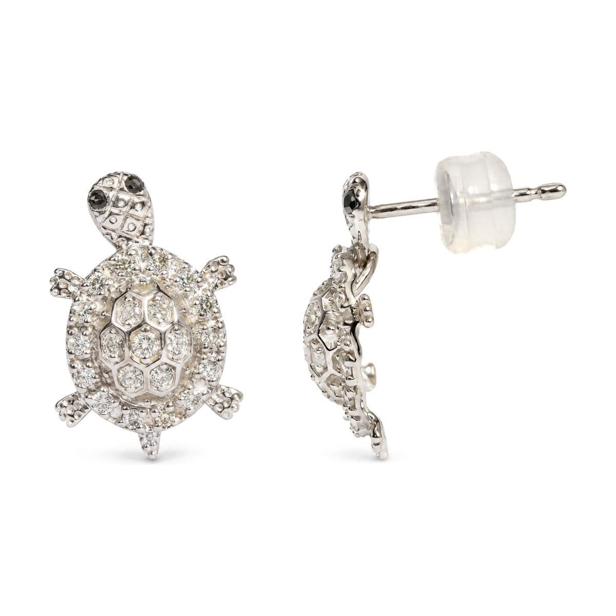 Close-up front and side angle of white metal turtle-shaped stud earrings with prong-set round white and black gemstones, shown on a white background.