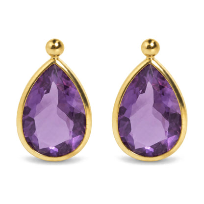 Close-up front view of yellow metal earrings with pear-shaped purple gemstones in bezel setting and round yellow metal studs above.
