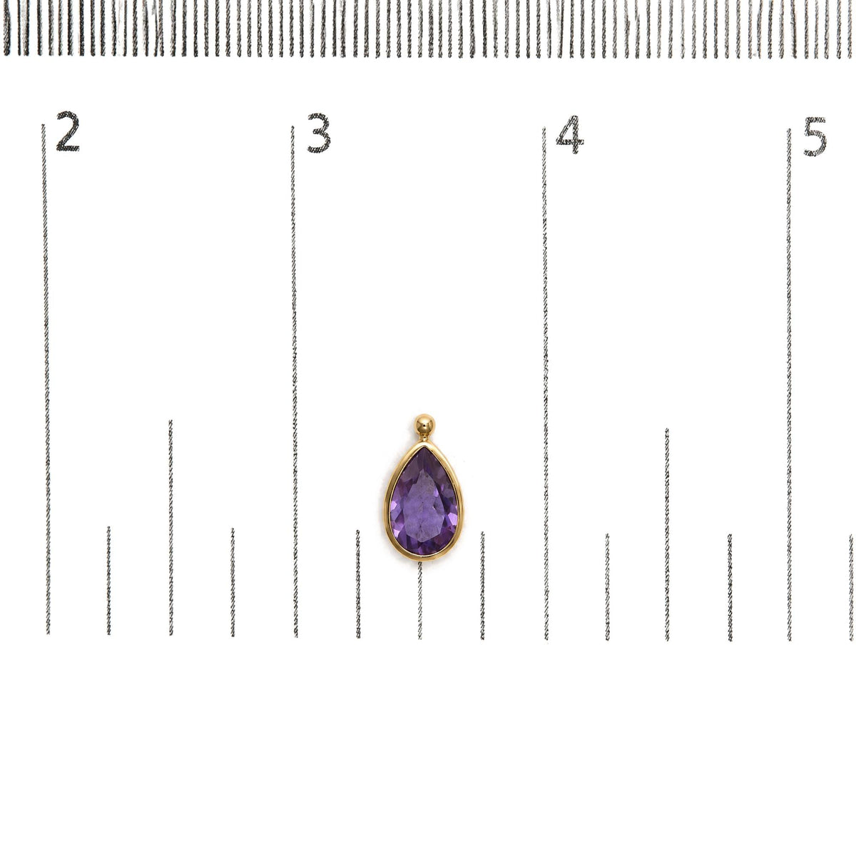 Close-up front view of a yellow metal earring with a pear-shaped purple gemstone in a bezel setting, shown on a scale.