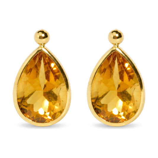 Close-up front view of yellow metal earrings featuring pear-shaped yellow gemstones in bezel settings.
