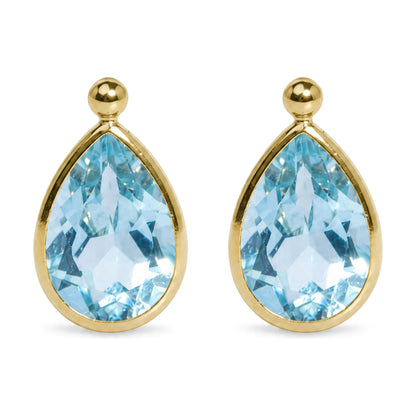 Close-up front view of yellow metal earrings featuring bezel-set pear-shaped blue gemstones.