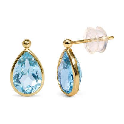 Close-up front and side view of a pair of yellow metal earrings with pear-shaped blue gemstones in bezel settings, shown isolated on a white background.