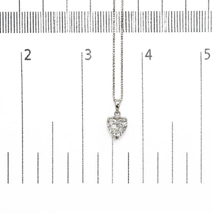 Close-up front view of a white metal necklace with a heart-shaped white gemstone pendant shown on a ruler for scale.