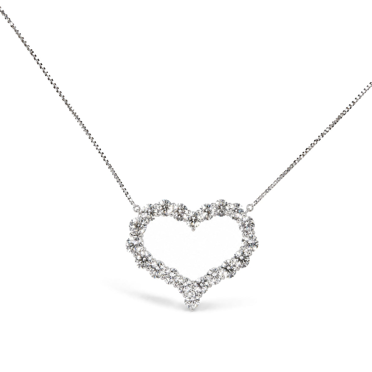 Close-up front angle of a white metal necklace with a heart-shaped pendant made of round white gemstones in prong settings.