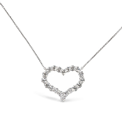 Close-up front angle of a white metal necklace with a heart-shaped pendant made of round white gemstones in prong settings.