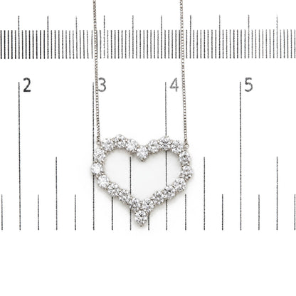Close-up front view of a white necklace with a heart-shaped pendant made of round white gemstones in prong settings, shown on a measurement scale.
