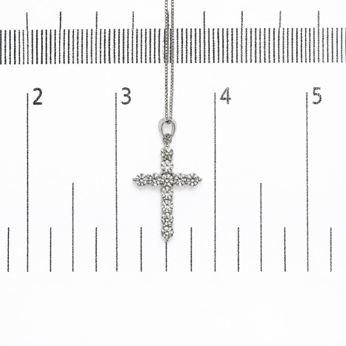 18K white gold lab-grown diamond cross pendant necklace shown on a measurement scale