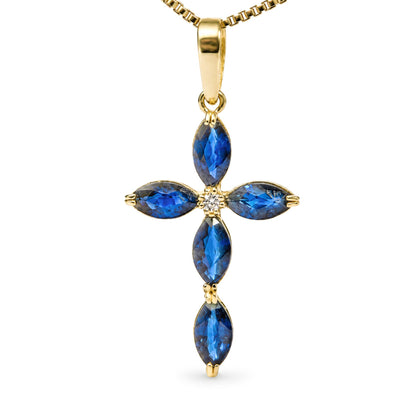 Close-up front view of a yellow metal necklace pendant shaped like a cross, featuring five marquise-shaped blue gemstones and one round white gemstone in the center, shown on a white background.
