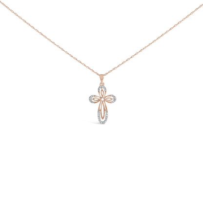 Front-facing shot of a rose metal necklace with a cross-shaped pendant featuring white round gemstones in prong settings.