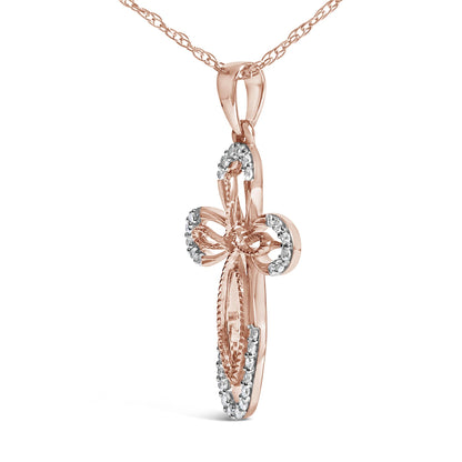 Rose-colored metal necklace with a cross-shaped pendant featuring round white gemstones in prong settings, shown in a close-up angled view.